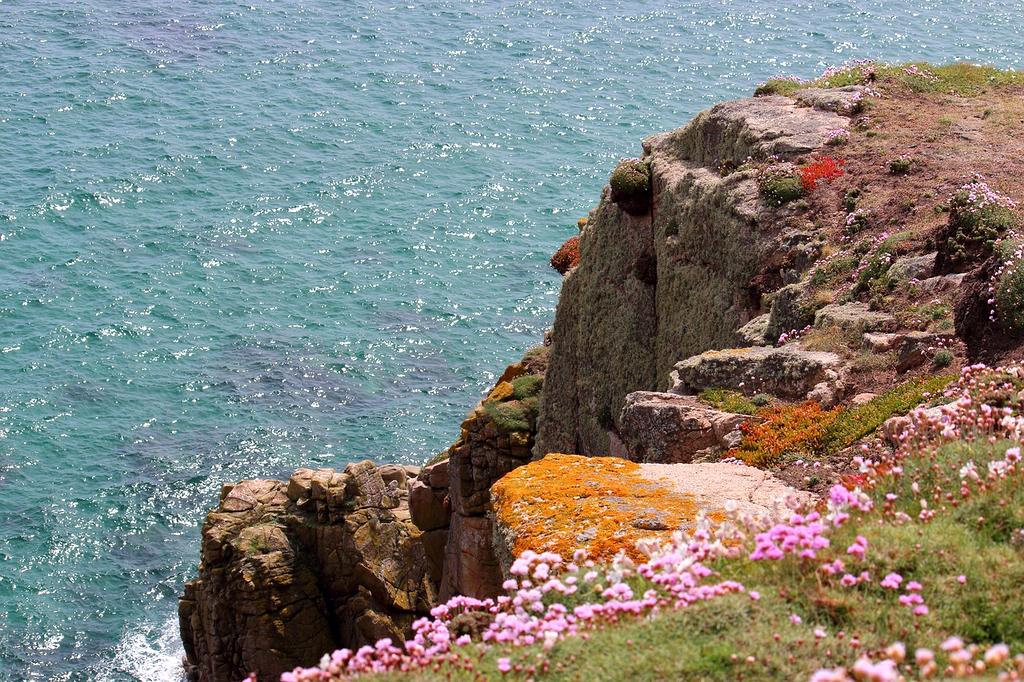 Sunset over the ocean in Cornwall with rugged cliffs