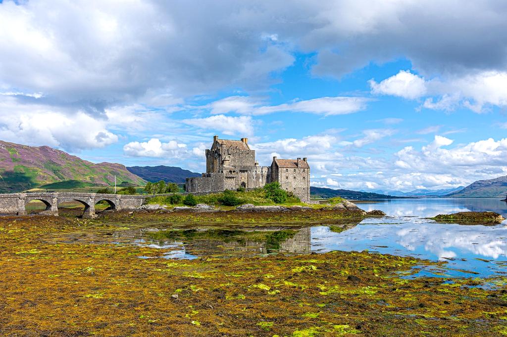 Historic castle ruins on a misty Scottish hillside